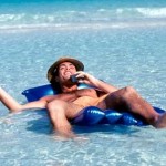 Man relaxing in surf while on cell phone